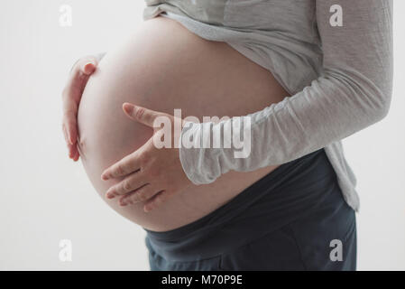 Pregnant woman tummy, female person in ninth month of pregnancy posing Stock Photo