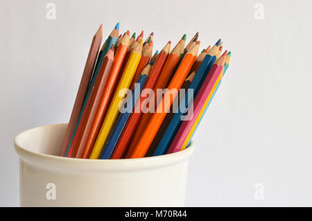 Colored pencils in a jar on a pale background Stock Photo