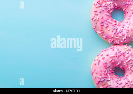 Two pink donuts on blue background. Stock Photo