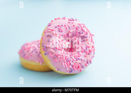 Two pink donuts on blue background. Stock Photo