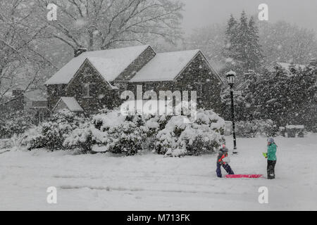 Wallingford, USA. 7th March, 2018. Two girls with sleds play in the snow as a winter storm / blizzard brings between 8' and 12' - a foot of snow to the East Coast of the United States during Quinn - a nor'easter - near Media PA Credit: Don Mennig/Alamy Live News Stock Photo