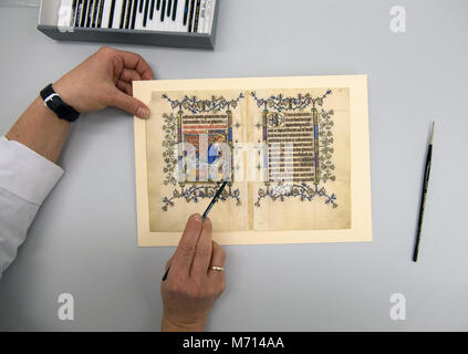 21 February 2018, Germany, Berlin: Restorer Katarzyna Schirmacher works on an original page of Mary of Guelders' prayer book. For the first time, parts of the more than 600-year-old prayer book of the medieval Queen consort of Scotland Mary of Guelders are to be publicly available soon. Photo: Ralf Hirschberger/dpa-Zentralbild/dpa Stock Photo