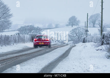 Flintshire, Wales, 8th March 2018. UK Weather. After a week of heavy snowfall and freezing temperatures further snow has fallen in some parts of the UK including Flintshire, with a Met Office Yellow warning in place for snow with heavy snowfall in the area. A driver braving the heavy snowfall in the rural village of Lixwm, Flinthsire, North Wales © DGDImages/Alamy Live News Stock Photo