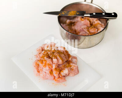 Chopped meat with spices on a top  and casserole with meat and knife on the table Stock Photo