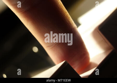 Close-up of finger pressing key piano keyboard Stock Photo