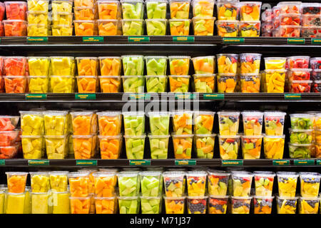 supermarket grocery display case with fresh cut fruit on shelves in plastic containe Stock Photo