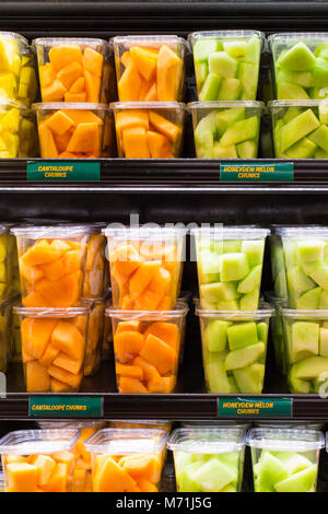 supermarket grocery display case with fresh cut fruit on shelves in plastic containe Stock Photo