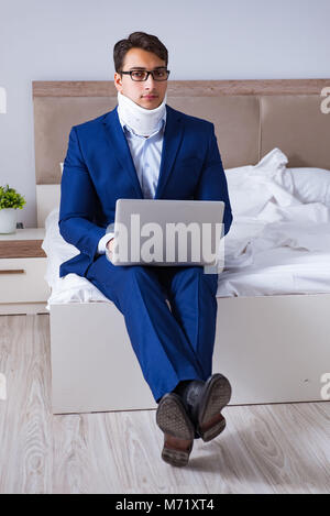 Businessman with neck injury working from home Stock Photo