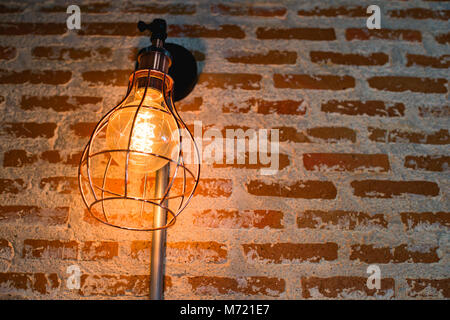 Decorative antique edison style light bulbs against brick wall background Stock Photo