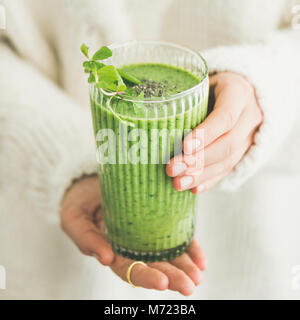 Matcha smoothie with chia seeds in female hands, square crop Stock Photo