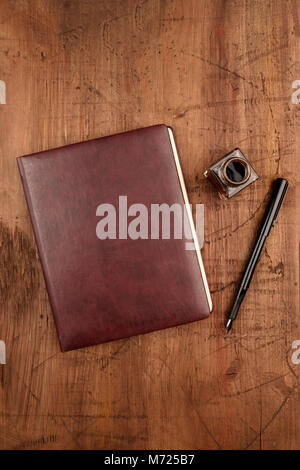 A leather bound journal, and ink well and pen Stock Photo