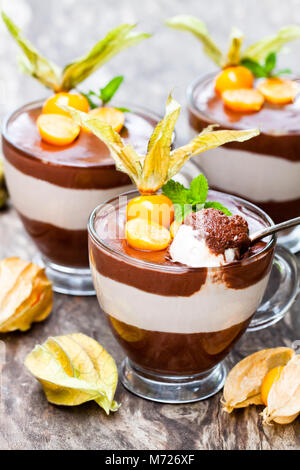Layered  dessert with physalis on wooden table Stock Photo