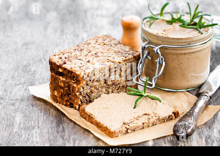 homemadeliver  pate with rosemary in a jar on a rustic wooden table Stock Photo