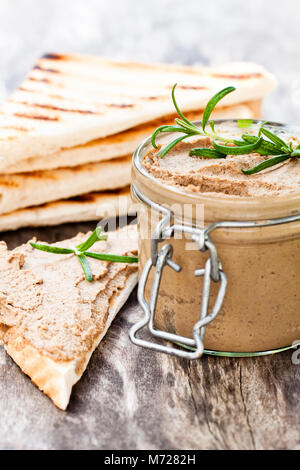 homemadeliver  pate with rosemary in a jar on a rustic wooden table Stock Photo