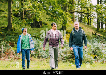 Three generation family are out hiking together. There is a senor man, his mature son and his teenage grandson. Stock Photo