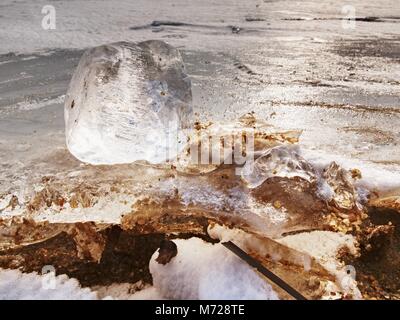 Beautiful epic ice crystal in the frozen bay.  Sun rays reflection in cracks, backlight  of the setting sun. Stock Photo