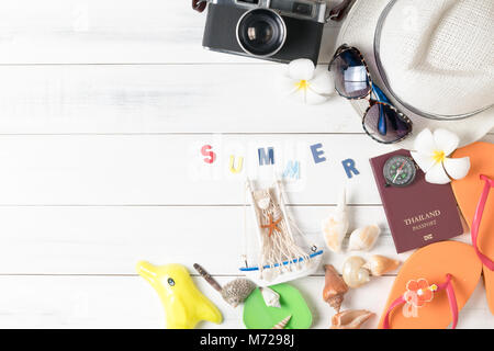 prepare accessories and travel items for summer, hat, sunglasses and beach slippers on white wooden board, flat lay, top view background Stock Photo
