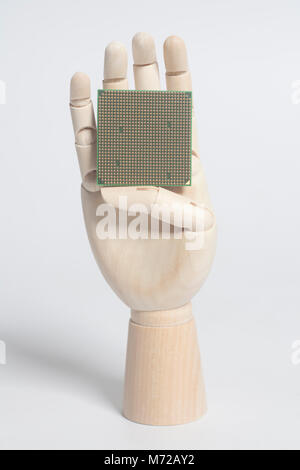 Wooden robot hand holding central processing unit CPU microchip on white Stock Photo