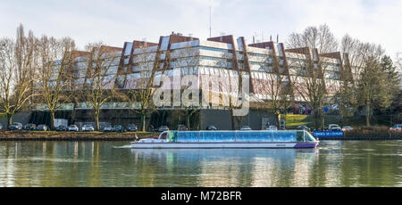 Back of the Council of Europe building with a tourist boat in the foreground touring on the Ill river, Strasbourg, France. Stock Photo