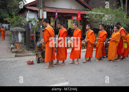 buddhist monks collectilg alms at daybreak in luang prabang laos Stock Photo