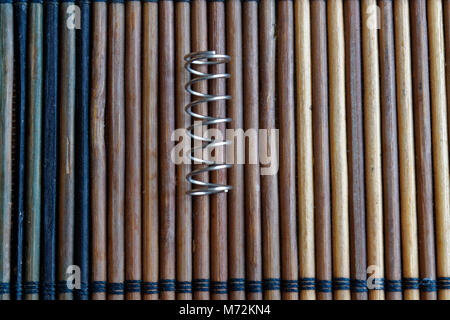 Steel spring with hooks on wooden background Stock Photo