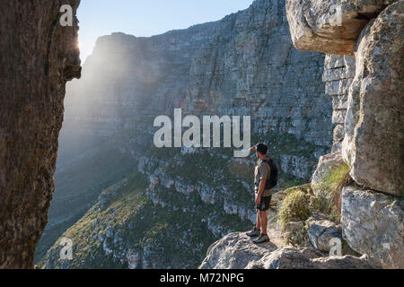 Hiker looking out from the “India Venster” rock formation on Table Mountain in Cape Town. Stock Photo