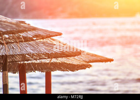 Sun loungers and umbrellas are on the beach in Budva, Montenegro. Sun flare Stock Photo