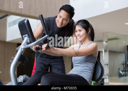 young asian couple workout in fitness gym Stock Photo