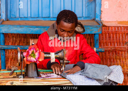 A Young Man Repairing Clothes Using An Old Fashioned Sewing Machine At The Saturday Market In The Dorze Village Of Chencha, Gamo Gofa Zone, Ethiopia Stock Photo