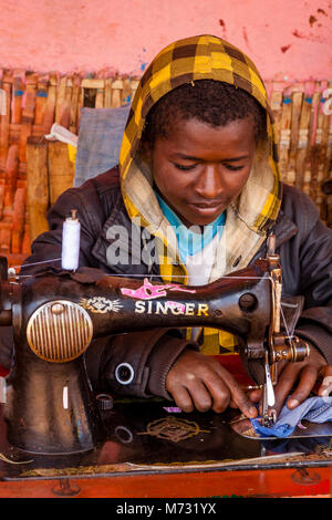 A Young Man Repairing Clothes Using An Old Fashioned Sewing Machine At The Saturday Market In The Dorze Village Of Chencha, Gamo Gofa Zone, Ethiopia Stock Photo