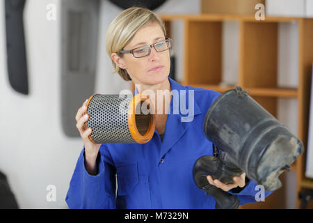 female mechanic holding car filter Stock Photo