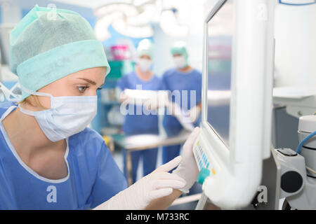 emale surgeon using digital tablet in operation room Stock Photo