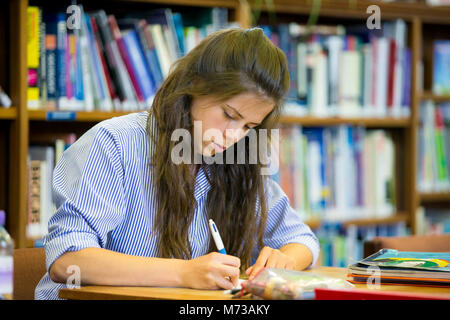 Senior school female student studying in the library of an English public school Stock Photo
