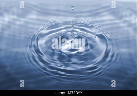 Water drop falling making droplet splash and waves clean and fresh concept Stock Photo