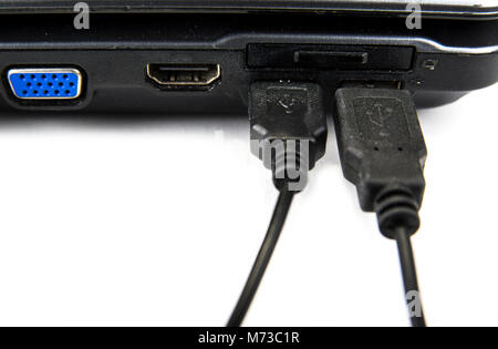 USB cable connected to the notebook on the white Stock Photo