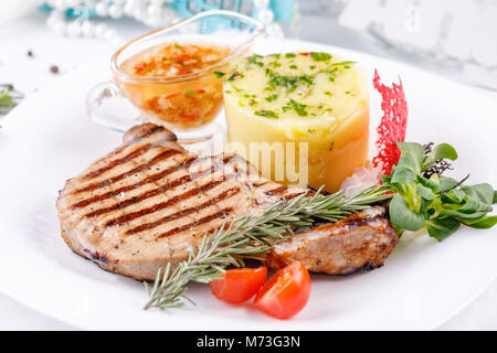 Appetizing loin on the bone with a garnish of mashed potatoes. Close-up. Stock Photo