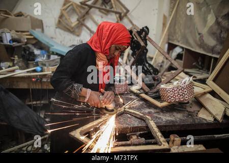 40-year-old Palestinian carpenter Amal Regaeg sands a frame on the 2018 International Women's Day at her workshop in al-Nuseirat refugee camp, Gaza Strip, 08 March 2018. Photo: Wissam Nassar/dpa Stock Photo