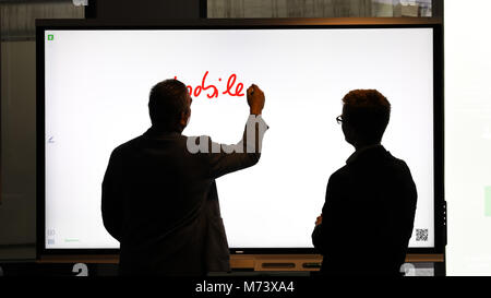 08 March 2018, Germany, Oldenburg: Two men, one of whom is writing, standing in front of an interactive "SMART" board in a classroom during the nationwide teacher training for digitisation. Photo: Mohssen Assanimoghaddam/dpa Stock Photo