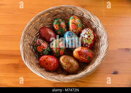 A basket with beautifully painted wooden eggs as Easter decoration. Stock Photo