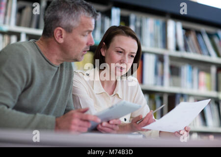 Mature students in library studying together Stock Photo