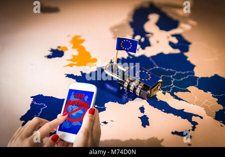 Female hands using a smartphone with Geo-blocking on screen. and Padlock over EU map Stock Photo
