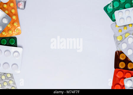 Packing of tablets of different colors on a white background with a place for the inscription Stock Photo