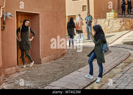 Abyaneh, Iran - April 26, 2017: young women take photos in the traditional countryside in the mountains. Stock Photo