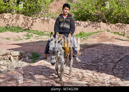 Abyaneh, Iran - April 26, 2017: Iranian boy is riding on a donkey in the  traditional village in the mountains. Stock Photo