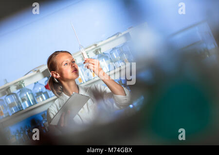 Portrait of a female researcher doing research in a chemistry lab (shallow DOF; color toned image) Stock Photo