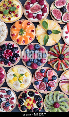 Colourful fruit tarts on a slate background Stock Photo