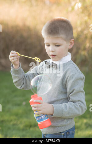 Seven year old boy playing outdoors in the Autumn Stock Photo