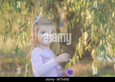 Young girl playing with bubbles outdoors in the autumn Stock Photo