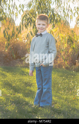 Seven year old boy playing outdoors in the Autumn Stock Photo