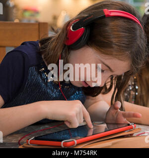 Square portrait of a young girl playing on a laptop. Stock Photo